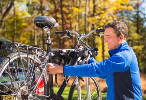 Man putting bicycle onto bike rack