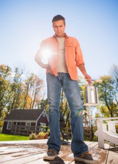 Man standing on porch with paint can