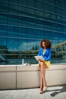 Young woman using digital tablet on ledge