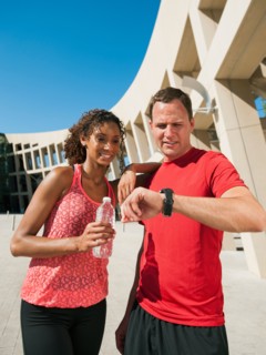 Man and woman checking time after jogging