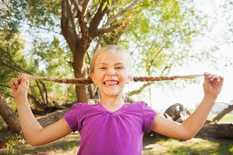 Little girl (4-5) holding out her pig tails as far as she can