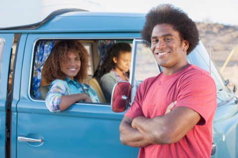 Man in foreground with friends during their road trip