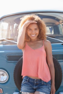 Portrait of smiling woman standing in front of van
