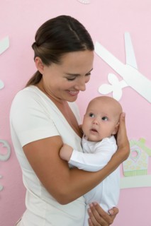Mother holding baby daughter (6-11 months)
