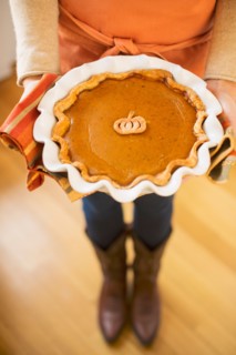 Woman holding pumpkin pie.