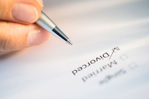 Close-up of hand filling out form.