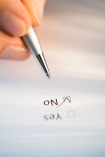 Close-up of hand filling out form.