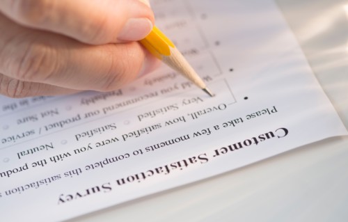 Close-up of hand filling out form.
