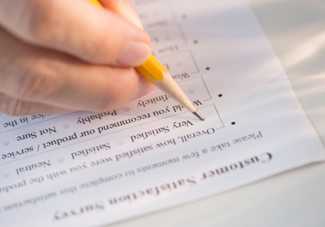 Close-up of hand filling out form.