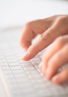 Close-up of hands typing on keyboard.