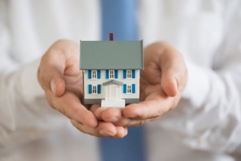 Man holding model house.