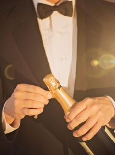 Elegant man opening champagne.