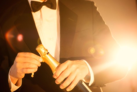 Elegant man opening champagne.