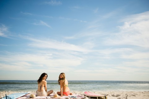 Two women relaxing on beach. Photo : Jamie Grill