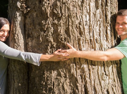 Couple embracing large tree. Photo : Jamie Grill