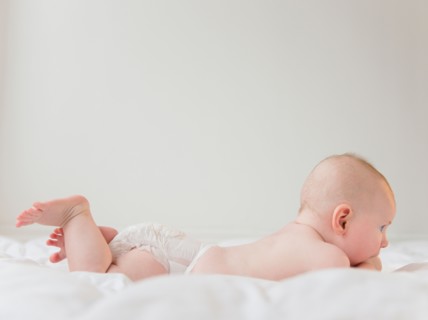 Baby boy (2-5 months) lying on front. Photo : Jamie Grill