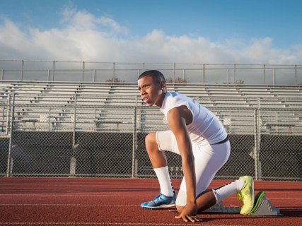 Boy (12-13) preparing for running on starting line. Photo: Erik Isakson