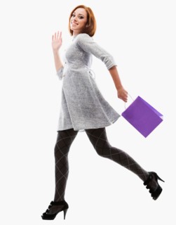 Young woman running with shopping bag, studio shot. Photo : Mike Kemp