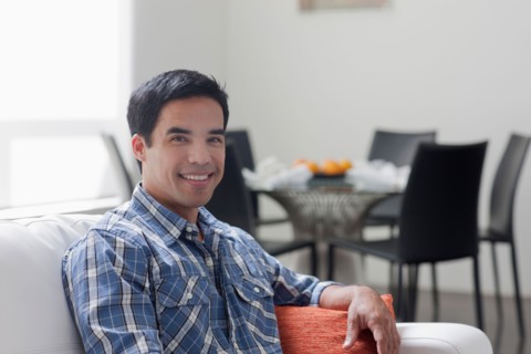 Portrait of man sitting in living room. Photo : Dan Bannister
