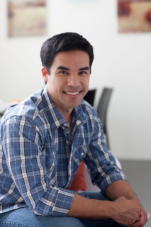 Portrait of man sitting in living room. Photo : Dan Bannister
