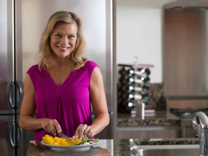Portrait of mature woman preparing salad. Photo : Dan Bannister