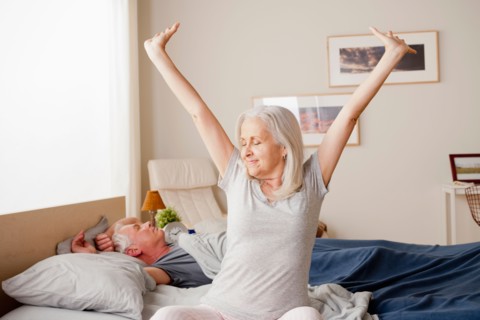 Senior woman stretching after waking up. Photo : Rob Lewine