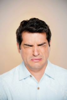 Portrait of man frowning with closed eyes. Photo : Rob Lewine