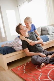 Cheerful couple embracing in bedroom. Photo : Rob Lewine