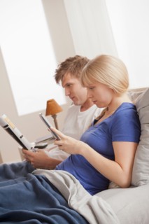 Couple sitting in bed reading. Photo : Rob Lewine