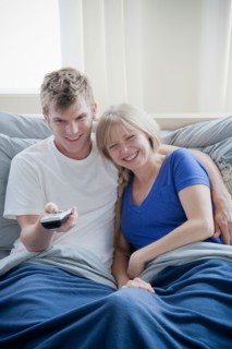 Couple watching television in bed. Photo : Rob Lewine
