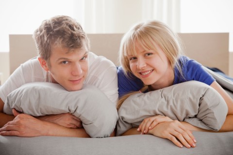Portrait of couple lying in bed. Photo : Rob Lewine