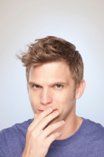 Portrait of man covering his mouth with hand. Photo : Rob Lewine