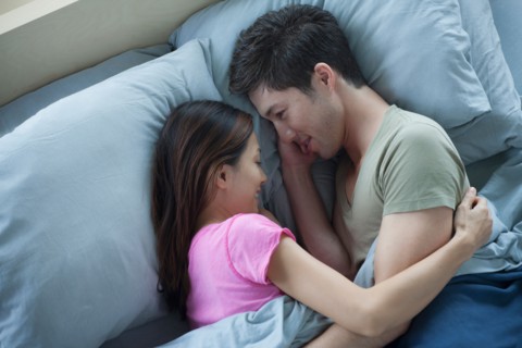 Elevated view of man and woman embracing in bed. Photo : Rob Lewine