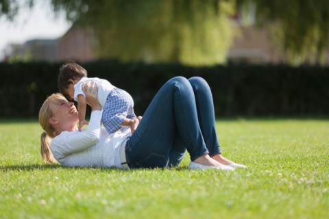 Mother with baby (6-11 months) playing on grass. Photo : Mark de Leeuw