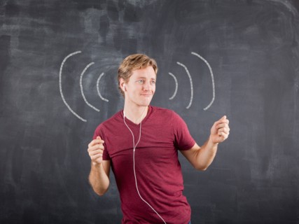 Studio shot of mid adult man listening to music on earphones and dancing with chalk drawing on