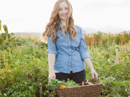 Portrait of young woman harvesting vegetables. Photo : Jessica Peterson