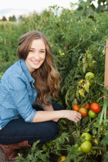 Portrait of young woman harvesting tomatoes. Photo: Jessica Peterson