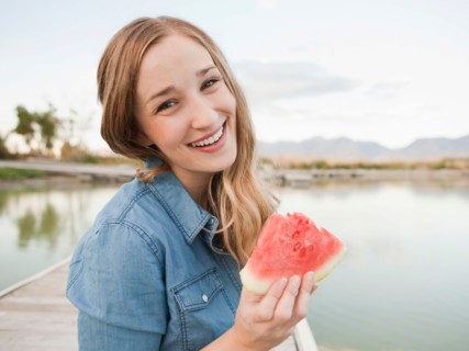 Portrait of young woman eating watermelon. Photo : Jessica Peterson