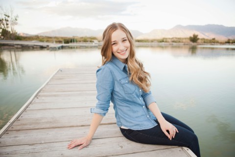 Portrait of young woman sitting on jetty. Photo : Jessica Peterson