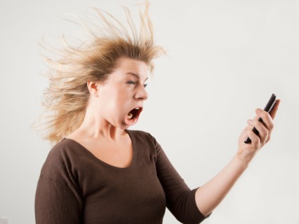 Studio shot of woman with windblown mouth holding phone. Photo : Jessica Peterson