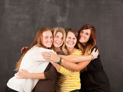 Studio portrait of four women embracing. Photo : Jessica Peterson