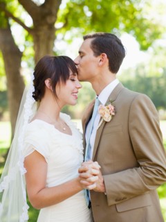 Groom kissing bride in park. Photo : Jessica Peterson