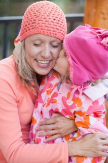 Daughter (4-5) kissing mother outdoors. Photo : Jessica Peterson