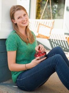 Portrait of young woman eating raspberries. Photo : Jessica Peterson
