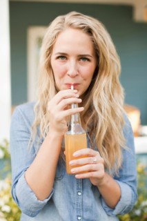 Front view portrait of young woman drinking soda through drinking straw. Photo : Jessica Peterson