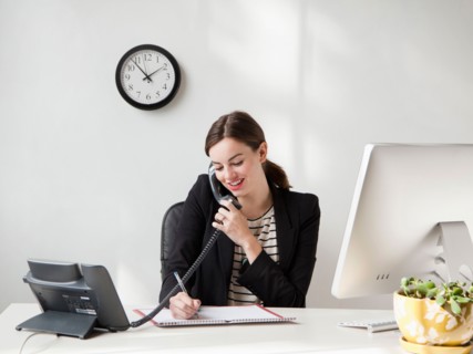 Studio shot of young woman working in office talking on phone . Photo: Jessica Peterson