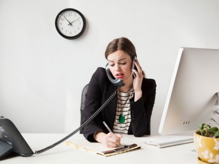 Studio shot of multi-tasking young woman working in office. Photo: Jessica Peterson