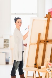 Woman painting at easel.