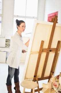 Woman painting at easel.