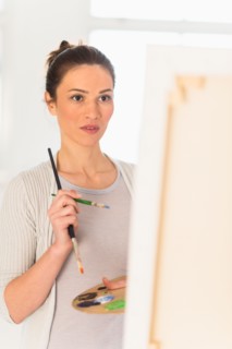 Woman painting at easel.